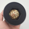 Kość metalowa D100 Lava Orb — Zdjęcie promo (z ręki)